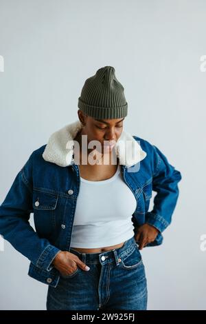 Femme portant une veste en denim sur fond blanc Banque D'Images