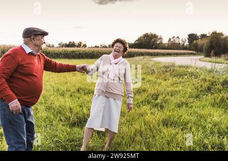 Joyeux couple senior appréciant et dansant sur le terrain Banque D'Images