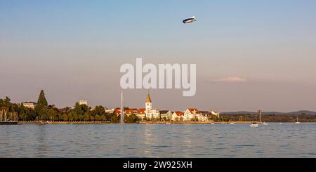 Allemagne, Bade-Wurtemberg, Friedrichshafen, Blimp survolant la ville sur la rive du lac Bodensee au crépuscule Banque D'Images