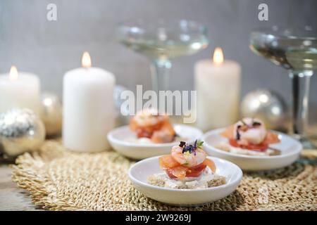 Canapés festifs avec crevettes et saumon, verres à champagne et bougies, apéritif pour une fête de Noël ou du nouvel an, espace copie Banque D'Images