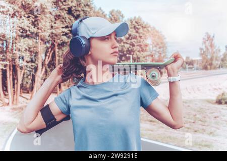 Portrait d'une adolescente avec un skateboard. Concept de style de vie sportif. Supports mixtes Banque D'Images