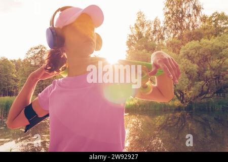 Portrait d'une adolescente avec un skateboard. Concept de style de vie sportif. Supports mixtes Banque D'Images