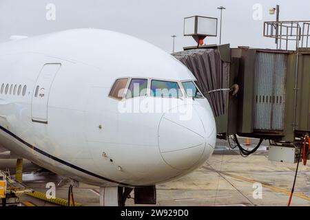 Les services au sol préparent l'avion de passagers pour le prochain décollage à la passerelle de la porte d'embarquement dans l'aéroport Banque D'Images