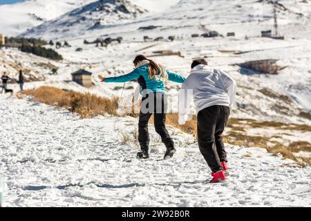 Des aventures glacées vous attendent ! Une famille latino se délecte dans les collines enneigées de la Sierra Nevada, Grenade, se livrant au plaisir glacial Banque D'Images