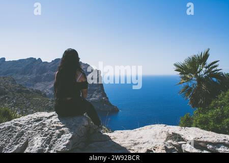 Beau portrait d'une jeune femme latine vêtue de noir devant la mer Banque D'Images