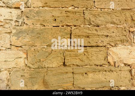 Gros plan d'un mur de pierre texturé avec des tons beiges variables et une surface rugueuse, texture de pierre typique de majorque juments Banque D'Images