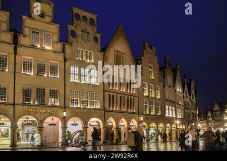 Münster, NRW, Allemagne. 23 décembre 2023. Les amateurs de Noël et les touristes se promènent le long de la jolie rue médiévale Prinzipalmarkt, dans la vieille ville gothique historique de Münster, par une dernière journée de shopping pluvieuse avant la veille de Noël. Crédit : Imageplotter/Alamy Live News Banque D'Images