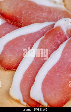 viande séchée salée en fines tranches sur papier, viande de porc en tranches Banque D'Images