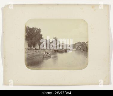 Vue du Mas Kali à Surabaya, Herman Salzwedel, 1876 - 1884 photographie vue du Mas Kali à Surabaya avec une poussette avec des personnages à gauche et un certain nombre de navires amarrés. A gauche une usine avec une grue et à droite une rangée de maisons sur la rivière. Partie de l'album photo du Surabayasche Vereeniging des fabricants de sucre offert à Frederik Beyerinck, résident de Surabaya. Surabaya support photographique albumen print Java. Surabaya Banque D'Images