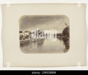 De Kali Mas, Herman Salzwedel, 1876 - 1884 photographie le Mas Kali près de Genteng à Surabaya avec un haut mur de quai avec des maisons sur la gauche. Un certain nombre d'échelles pendent dans l'eau depuis le quai. A droite de la rivière, le quai est envahi par la végétation et il y a des arbres. Partie de l'album photo du Surabayasche Vereeniging des fabricants de sucre offert à Frederik Beyerinck, résident de Surabaya. Surabaya support photographique impression albumen Surabaya Banque D'Images