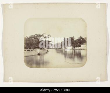 De Kali Mas, Herman Salzwedel, 1876 - 1884 photographie le Mas Kali à Surabaya avec un haut mur et des arbres à gauche, une maison au milieu et aussi une maison à droite. Un seul prauw est amarré au loin. Partie de l'album photo du Surabayasche Vereeniging des fabricants de sucre offert à Frederik Beyerinck, résident de Surabaya. Surabaya support photographique impression albumen Surabaya Banque D'Images