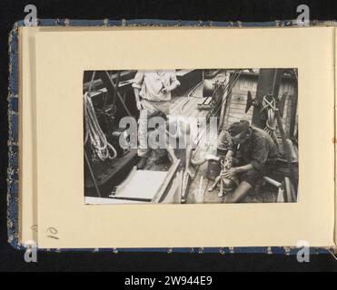 Marins à bord de leur navire avec un chien, 1940 - 1943 photographie marins allemands au travail à bord de leur navire, l'un d'eux joue avec un chien. Partie de l'album photo sur la Kriegsmarine 1940-1943. France (éventuellement) support photographique gélatine argentique imprimer la compagnie, l'unité, la troupe  service militaire. Marin France Banque D'Images