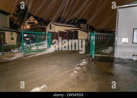 231224Überflutung News ID : FR 2023-12-24 Extremes Tauwetter : Freibad übergelaufen Lungwitzbach über die Ufer getrett Region. Starkes Tauwetter und Starker Regen haben im Erzgebirge und im Landkreis Zwickau für zum Teil schwere Überflutungen gesorgt. Im erzgebirgischen Neukirchen fluteten das Schmelzwasser und der Regen ein Freibad. Die Becken konnten das viele Wasser nicht aufnehmen, sodass diese überliefen. Die Wassermassen schossen anschließend durch ein Tor auf die angrenzende Max-Weigelt-Straße und sorgte hier für vollgelaufene Keller. Die Feuerwehr war hier machtlos. Auch dans anderen Ort Banque D'Images