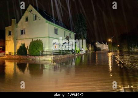 231224Überflutung News ID : FR 2023-12-24 Extremes Tauwetter : Freibad übergelaufen Lungwitzbach über die Ufer getrett Region. Starkes Tauwetter und Starker Regen haben im Erzgebirge und im Landkreis Zwickau für zum Teil schwere Überflutungen gesorgt. Im erzgebirgischen Neukirchen fluteten das Schmelzwasser und der Regen ein Freibad. Die Becken konnten das viele Wasser nicht aufnehmen, sodass diese überliefen. Die Wassermassen schossen anschließend durch ein Tor auf die angrenzende Max-Weigelt-Straße und sorgte hier für vollgelaufene Keller. Die Feuerwehr war hier machtlos. Auch dans anderen Ort Banque D'Images