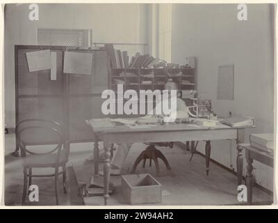 Man Behind Table, 1898 Photographie D'Un homme assis derrière sa table de travail. Probablement membre des rédacteurs du Deli courant à Medan. Il y a un calendrier sur un écran avec le mois de septembre de l'année 1898. Fait partie d'un groupe de 8 photos de septembre 1898 dans le groupe de 49 photos en noir et blanc en vrac de différents formats sur la maison d'édition et l'imprimerie du journal Deli courant à Medan dans la période 1885-1947. Alors que les photographies soutiennent les Indes orientales néerlandaises, les. Medan Banque D'Images
