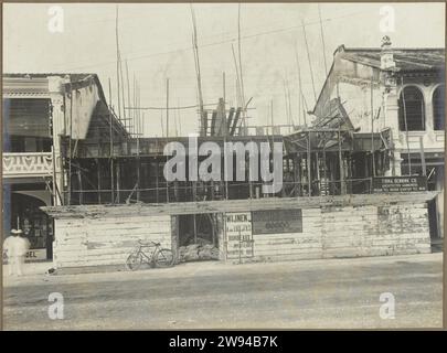 Chantier de construction, 1914 - 1919 photographier le chantier de construction d'un immeuble dans un pâté de maisons d'une rue, probablement à Medan. Sur la clôture est un signe de l'artiste : Bennink Co. Firm. Architectes entrepreneurs. Photo dans l'album photo du cabinet d'architectes néerlandais Bennink et de la société d'entrepreneurs Riphagen à Medan dans les années autour de 1914-1919. Alors que le support photographique gélatine argentique impression tandis que Banque D'Images