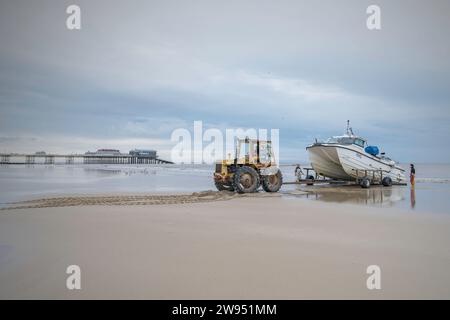 Pêcheurs avec bateau et tracteur sur la plage, Cromer, Norfolk, Royaume-Uni Banque D'Images