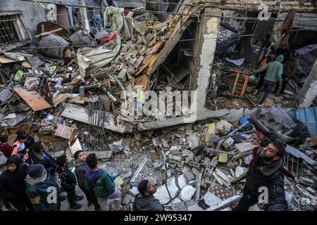 Rafah, Territoires palestiniens. 24 décembre 2023. Des Palestiniens inspectent un bâtiment détruit appartenant à la famille Abu Al-AWF après une frappe aérienne israélienne sur Rafah, dans le sud de la bande de Gaza. Deux personnes ont été tuées à l'intérieur. Crédit : Abed Rahim Khatib/dpa/Alamy Live News Banque D'Images