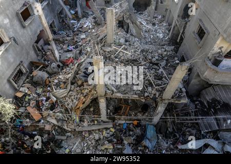 Rafah, Territoires palestiniens. 24 décembre 2023. Des Palestiniens inspectent un bâtiment détruit appartenant à la famille Abu Al-AWF après une frappe aérienne israélienne sur Rafah, dans le sud de la bande de Gaza. Deux personnes ont été tuées à l'intérieur. Crédit : Abed Rahim Khatib/dpa/Alamy Live News Banque D'Images