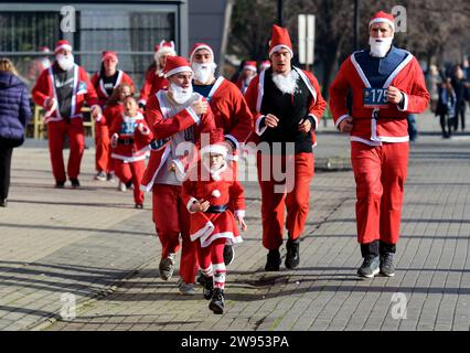 Les participants habillés en Santa Clause courent lors de la course traditionnelle du Père Noël à Skopje, Macédoine du Nord, du 24 au 17 décembre 2023. IMAGO/PETR STOJANOVSKI Banque D'Images