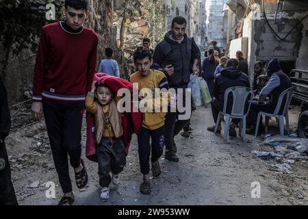 Rafah, Territoires palestiniens. 24 décembre 2023. Les Palestiniens marchent avec leurs affaires après une frappe aérienne israélienne sur le bâtiment de la famille Abu Al-AWF à Rafah, dans le sud de la bande de Gaza. Deux personnes ont été tuées à l'intérieur. Crédit : Abed Rahim Khatib/dpa/Alamy Live News Banque D'Images