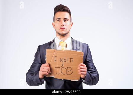 Young businessman holding un morceau de carton en disant qu'il a besoin d'un emploi Banque D'Images
