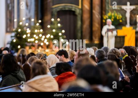 Berlin, Allemagne. 24 décembre 2023. Une femme portant un foulard prend part à un service de Noël de la « Maison de l'un » interconfessionnelle avec des invités juifs et musulmans à Saint L'église de Marie sur Alexanderplatz, avec l'Imam Osman ors parlant en arrière-plan. Crédit : Christoph Soeder/dpa/Alamy Live News Banque D'Images