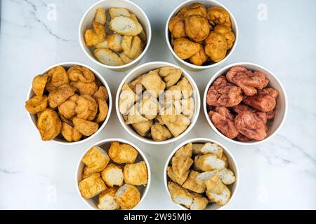 Les boulettes de viande frites faites à partir d'une variété de viandes et de saucisses, mélangées avec de la farine et des assaisonnements sur fond de marbre blanc. Boulettes de viande frites à base de m Banque D'Images