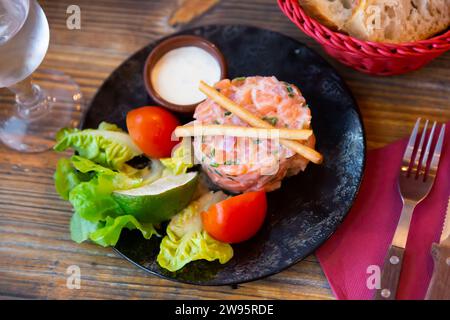 Tartare de saumon à la crème à la ciboulette, aux légumes, à la chaux et aux bâtonnets de pain Banque D'Images