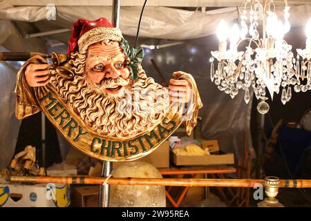 Bas-relief sculpté dans le bois avec l'image du Père Noël et les mots Joyeux Noël à un marché d'antiquités de Noël Banque D'Images