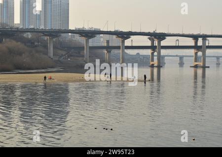 Les Coréens locaux pêchent sur les bancs de sable de la rivière Han avec le pont de Cheongdam en arrière-plan Banque D'Images