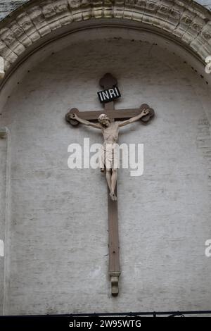 Un Jésus Christ en marbre sur une croix en bois avec les lettres 'INRI' au-dessus de sa tête à l'église notre-Dame de Bruges Banque D'Images