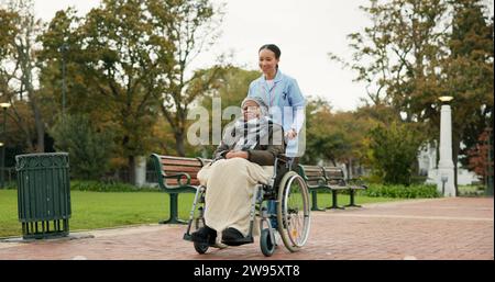 Infirmière, marche et parc avec une vieille femme en fauteuil roulant pour la retraite, les soins aux personnes âgées et la physiothérapie. Confiance, médical et soins de santé avec senior Banque D'Images