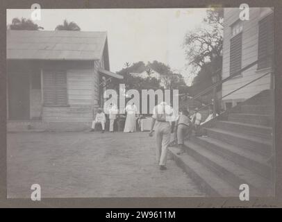 Sur le court de tennis, Anonymous, 1910 - 1914 photographiez Un groupe de personnes, dont probablement des membres de la famille Gonggrijp, sur le court de tennis de Paramaribo. Fait partie d'un groupe de onze lames d'album avec des photos de famille de la famille Gonggrijp au Suriname, ca. 1912. Soutien photographique Suriname tennis, tennis sur gazon Suriname. Paramaribo Banque D'Images