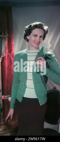 Années 1950, historique, rose anglaise, mode féminine de l'époque, une jeune femme portant un gilet en laine doux de couleur vert clair et un haut en laine rayé, Angleterre, Royaume-Uni. Banque D'Images