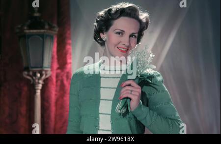 Années 1950, historique, rose anglaise, mode féminine de l'époque, une jeune femme portant un gilet en laine doux de couleur vert clair et un haut en laine rayé, Angleterre, Royaume-Uni. Banque D'Images