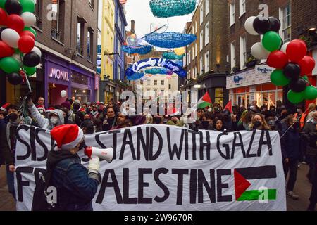 Londres, Royaume-Uni. 23 décembre 2023. Manifestants dans Carnaby Street. Les manifestants pro-palestiniens ont défilé dans le quartier commerçant de Londres avant Noël, appelant à un cessez-le-feu. Crédit : Vuk Valcic/Alamy Banque D'Images