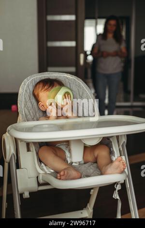 Un petit enfant mange de la purée de légumes. Maman nourrit le bébé. Banque D'Images