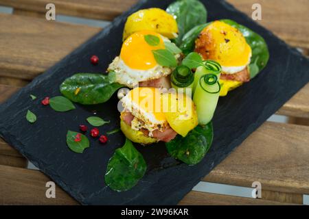 Gros plan de mini hamburgers à partir d'œufs de caille avec des pommes de terre cuites au four dans l'assiette avec des légumes verts sur la table Banque D'Images