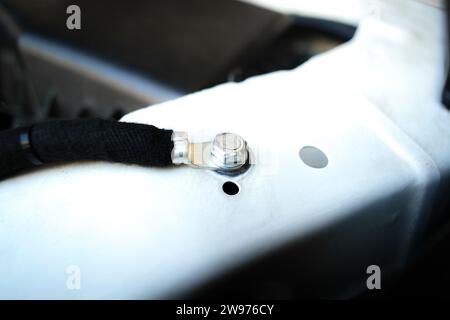 Fil de masse ou électrode négative sur le châssis de voiture dans le compartiment moteur pour le système électrique de la voiture , concept de pièces de voiture Banque D'Images