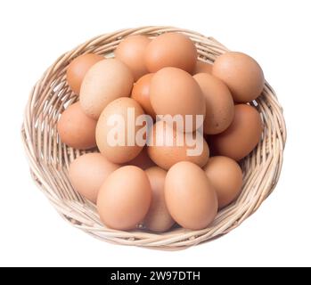 Les œufs de poule frais dans le panier en bambou tissé sont isolés sur fond blanc avec chemin de découpage. Photo vue de dessus Banque D'Images