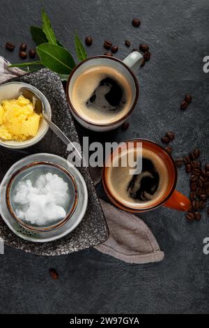 Café céto pare-balles. Régime cétogène. Dring chaud avec de l'huile de noix de coco et du beurre de ghee sur fond sombre. Vue de dessus Banque D'Images