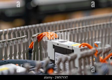 Une chaîne de montage en usine avec une armoire électronique ouverte, révélant le câblage complexe et les composants Banque D'Images