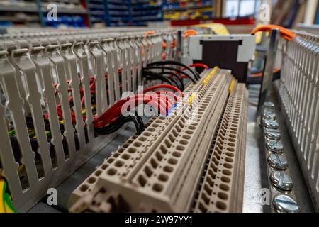 Une chaîne de montage en usine avec une armoire électronique ouverte, révélant le câblage complexe et les composants Banque D'Images