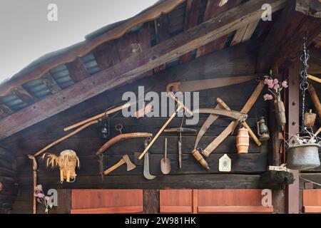 Un vieux chalet en bois avec une gamme d'outils accrochés au mur. Valais Banque D'Images