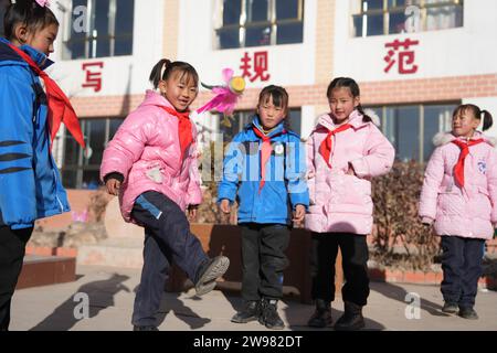 Jishan, province chinoise du Gansu. 25 décembre 2023. Les élèves jouent à des jeux pendant une pause scolaire dans une école primaire du canton de Liugou, dans le comté de Jishan, dans la province du Gansu, au nord-ouest de la Chine, le 25 décembre 2023. Les écoles primaires et secondaires dans les zones de Jishishan touchées par le séisme ont commencé à reprendre les cours lundi après un contrôle de sécurité. Crédit : Chen Bin/Xinhua/Alamy Live News Banque D'Images