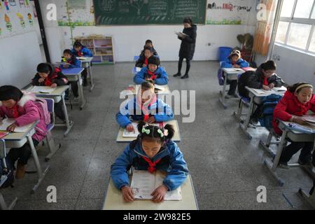 Jishan, province chinoise du Gansu. 25 décembre 2023. Les élèves fréquentent une classe dans une école primaire du canton de Liugou, dans le comté de Jishan, dans la province du Gansu, au nord-ouest de la Chine, le 25 décembre 2023. Les écoles primaires et secondaires dans les zones de Jishishan touchées par le séisme ont commencé à reprendre les cours lundi après un contrôle de sécurité. Crédit : Chen Bin/Xinhua/Alamy Live News Banque D'Images