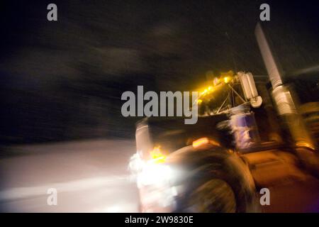 Un semi-trudges à travers une tempête de neige au-dessus de donner Summit dans le nord de la Californie. (Image floue). Banque D'Images