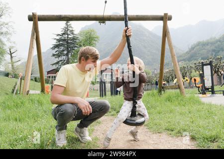 Père monte sa petite fille sur une tyrolienne pour enfants Banque D'Images