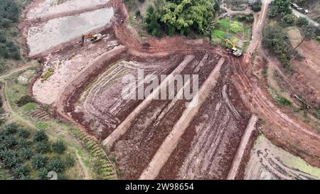 CHONGQING, CHINE - le 25 DÉCEMBRE 2023 - une excavatrice aplatit le terrain sur le site de construction de terres agricoles de haute qualité dans le village de Tianxingqiao, à Chongqi Banque D'Images